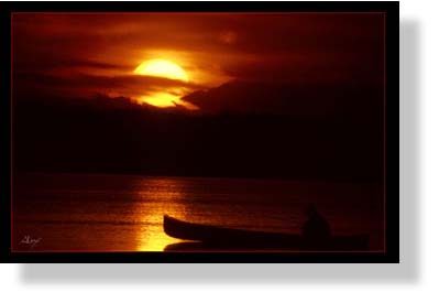 man in a canoe at sunset